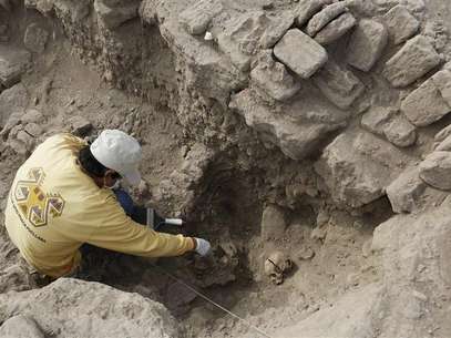 Un arqueólogo limpia restos de una tumba de una momia de la cultura Wari en Miraflores, Perú, oct 24 2013. Dos fardos funerarios de unos 1.000 años de antigüedad, con un adulto y un niño adentro, fueron encontrados intactos en un complejo ceremonial preincaico en la capital de Perú, dijo el jueves la arqueóloga a cargo del hallazgo. Foto: Mariana Bazo / Reuters